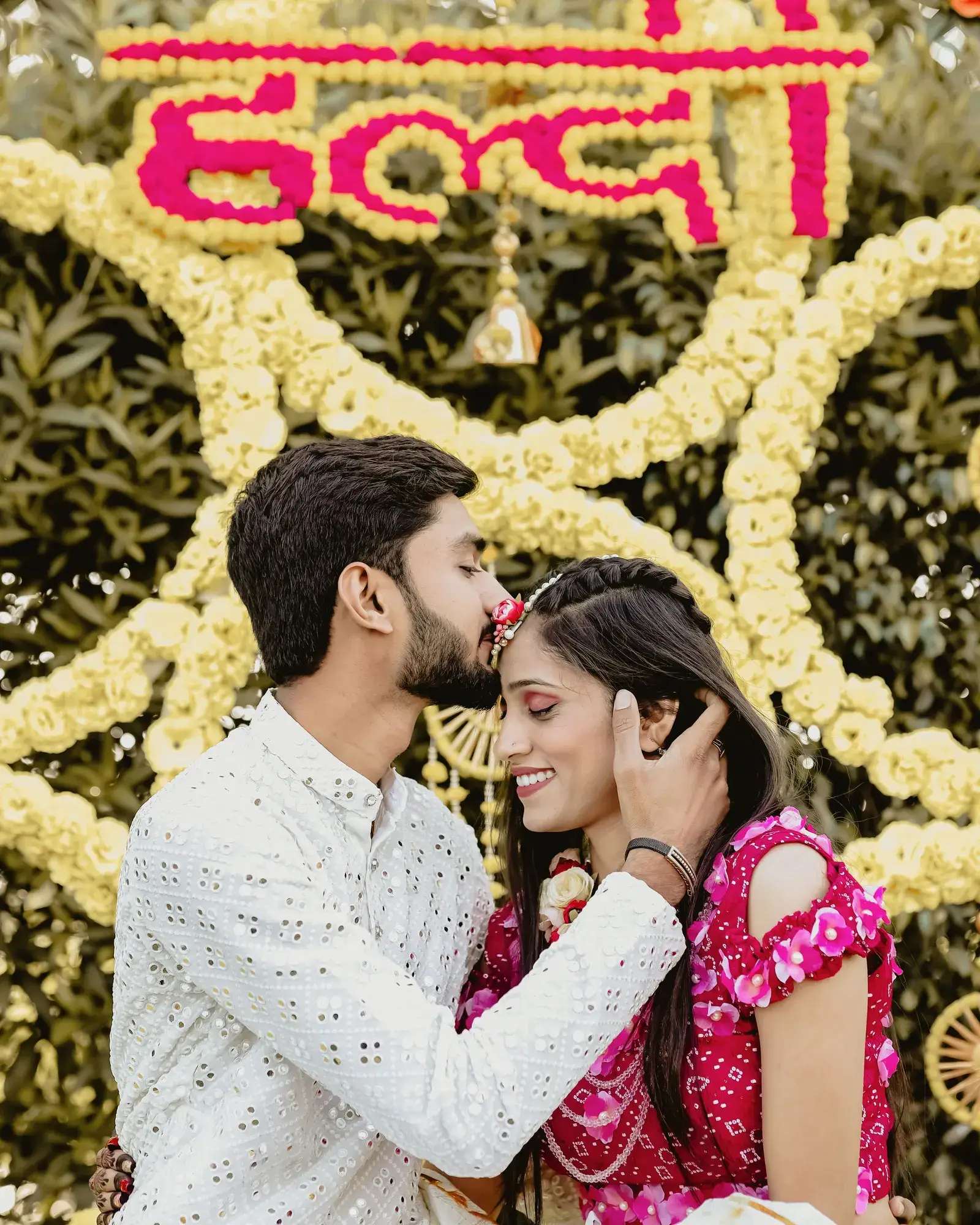 Temporary concept image of a couple laughing together amid marigold décor during a haldi ceremony; not property photography.