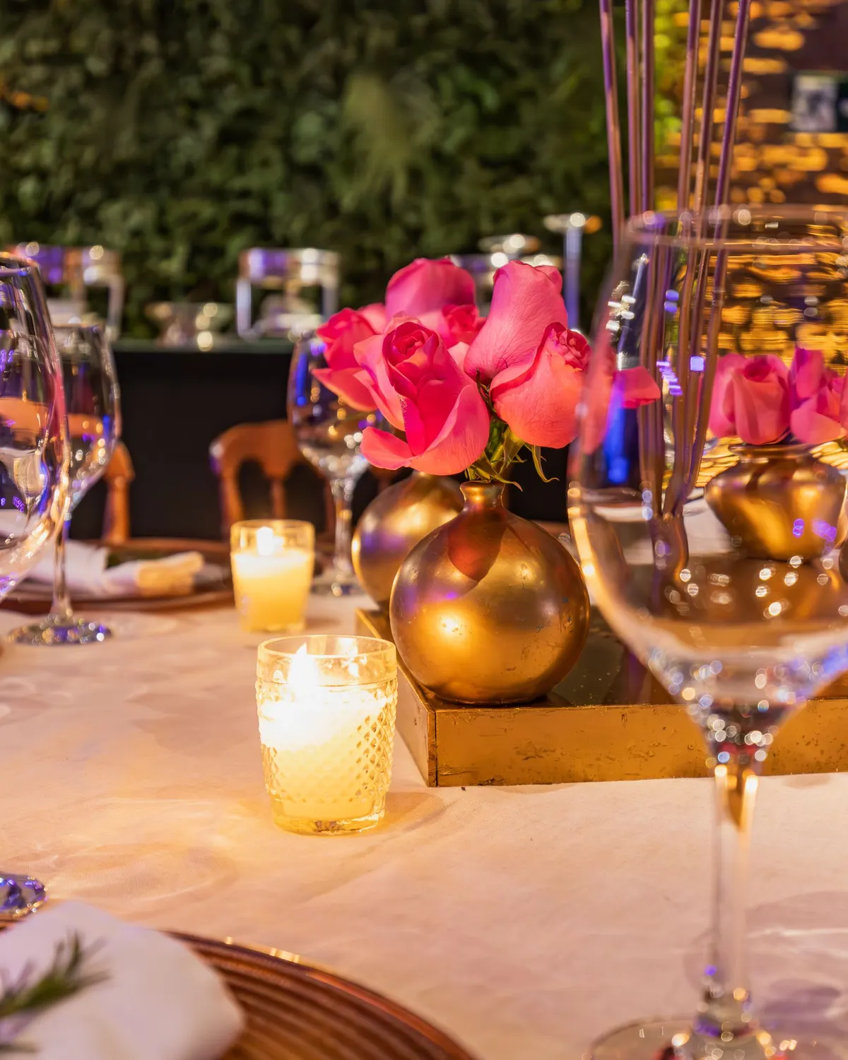 Temporary concept image of celebration table with candles, roses and glassware at night; not property photography.