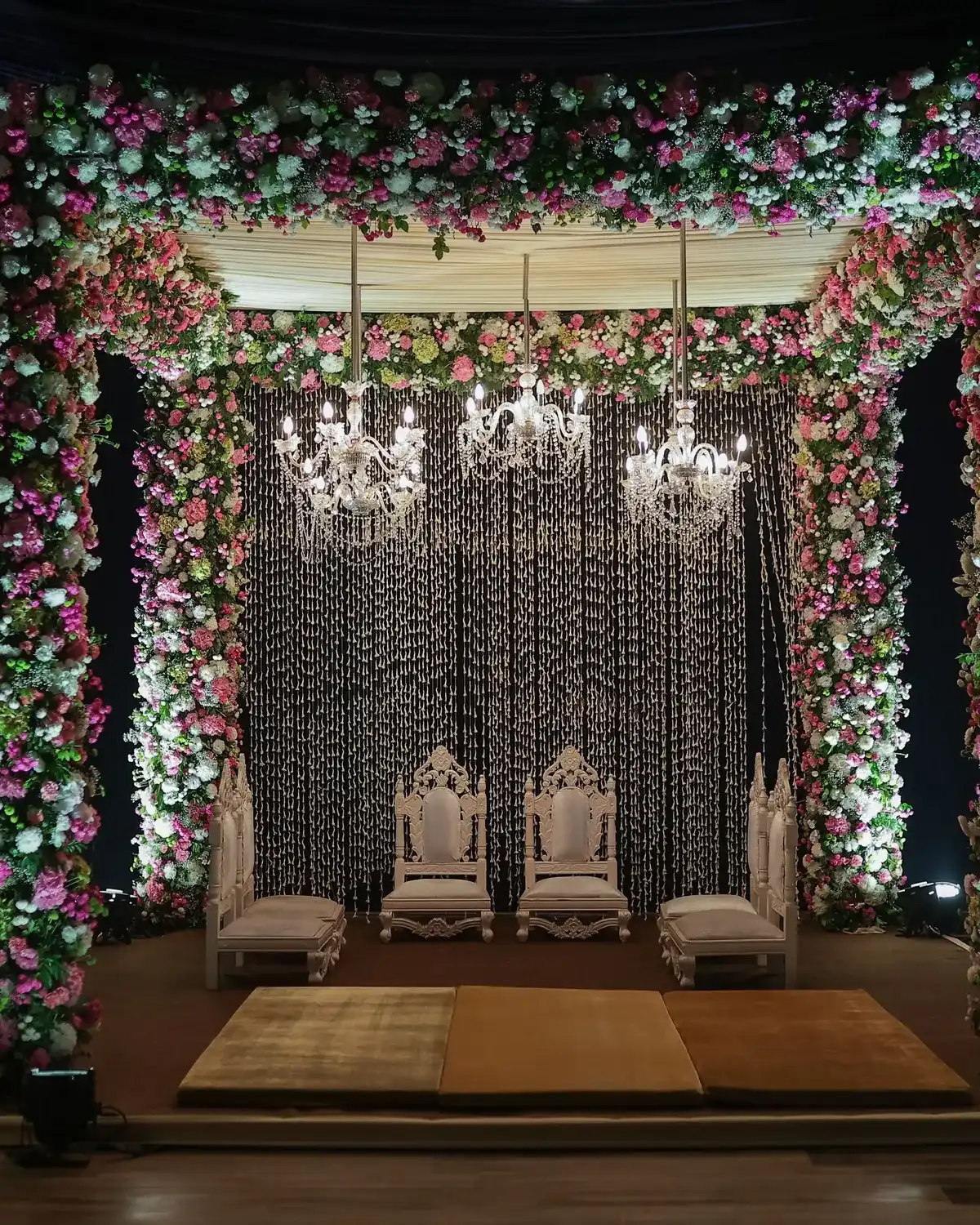 Temporary concept image of floral mandap with chandeliers prepared for a wedding ceremony; not property photography.