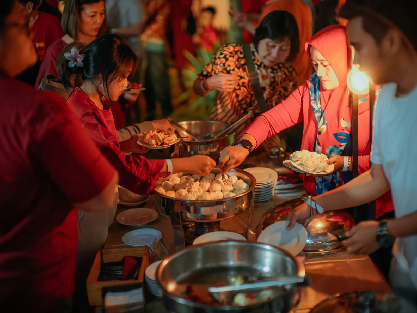 Temporary concept image of family and friends gathered around a warm candlelit dinner buffet; not property photography.