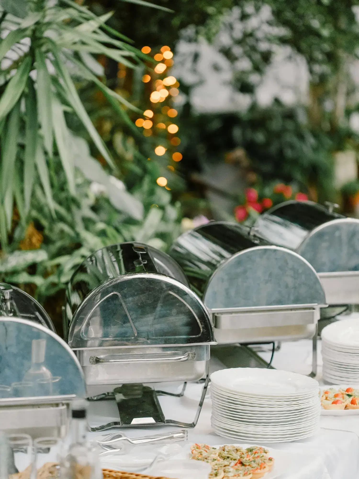 Temporary concept image of buffet dishes arranged on white linen in an outdoor setting; not property photography.