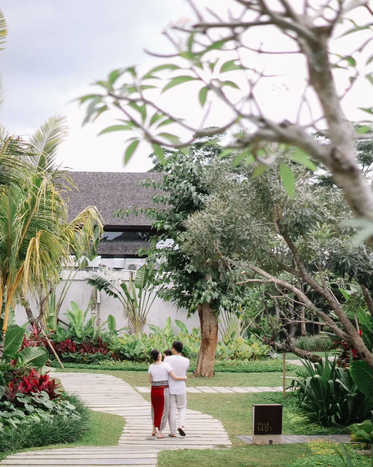 Temporary concept image of a couple walking hand in hand through a lush garden path; not property photography.