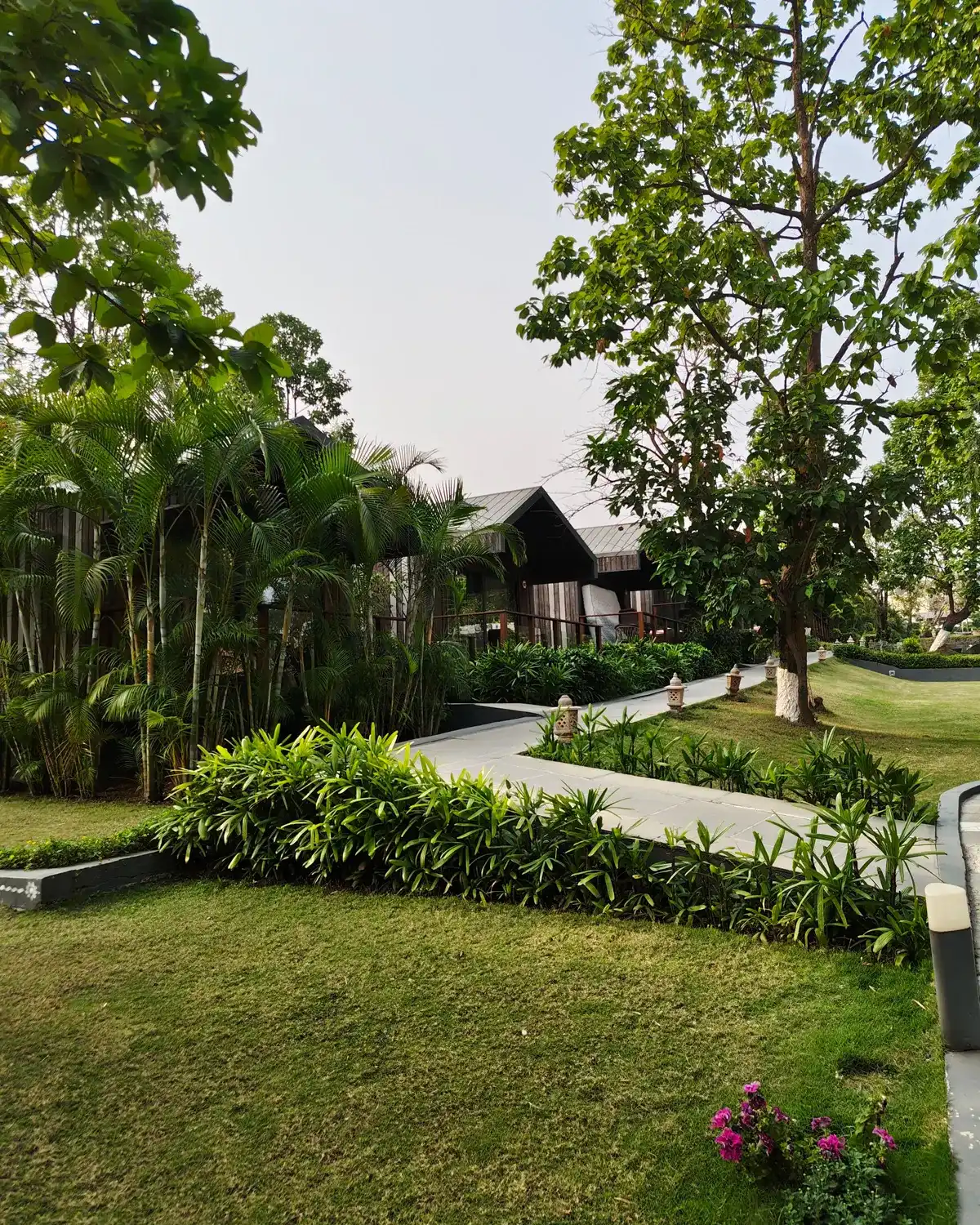 Temporary concept image of landscaped garden pathway with stone lanterns leading toward low cottages; not property photography.