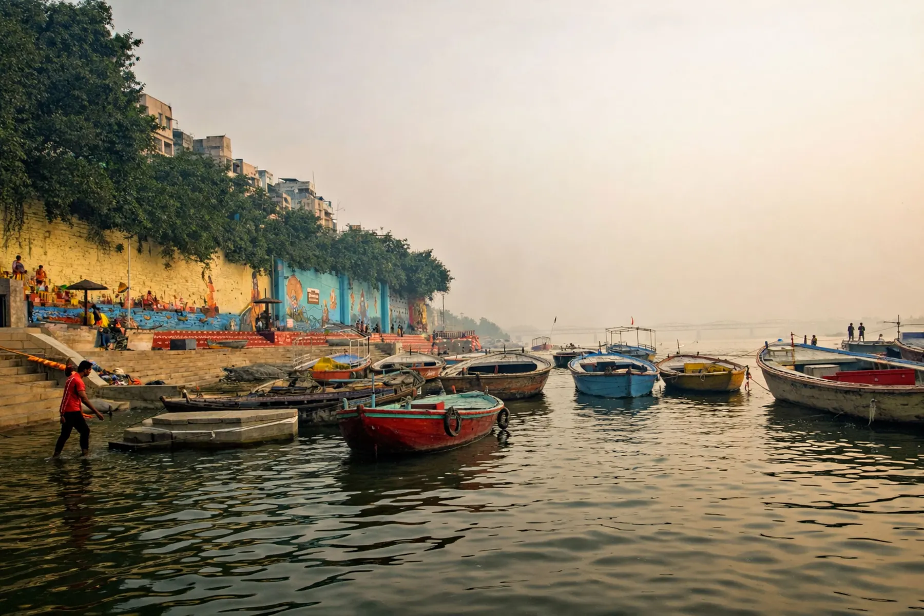 Temporary concept image of wooden boats moored on the Ganga at dawn with ghats rising behind; not property photography.
