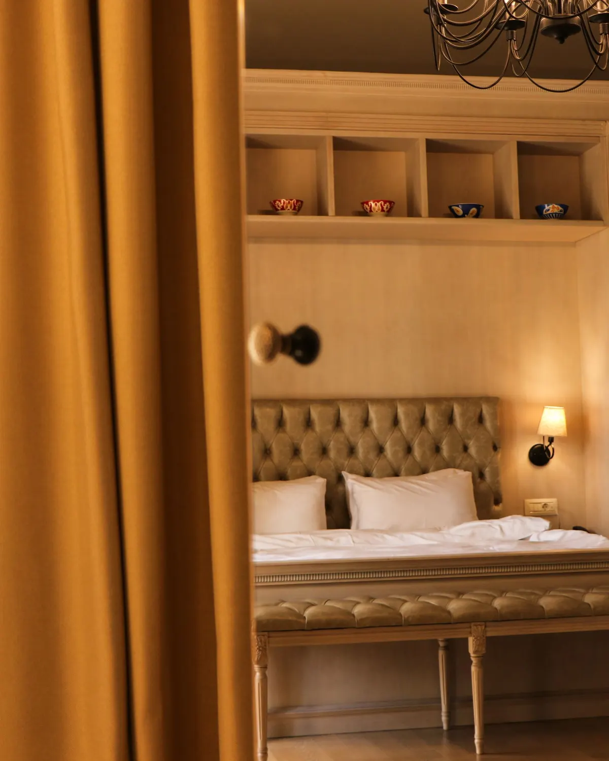Temporary concept image of warmly lit hotel bedroom with plush bedding and soft lamplight; not property photography.