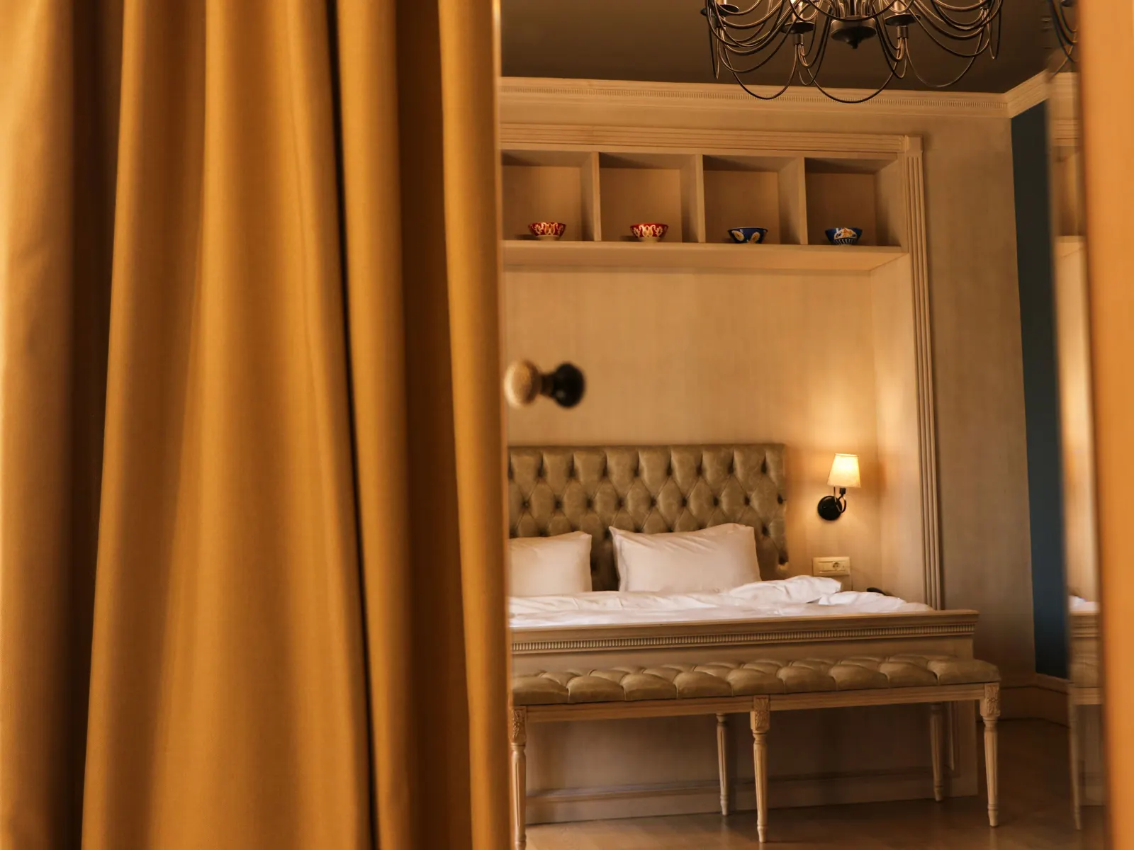 Temporary concept image of warmly lit hotel bedroom with plush bedding and soft lamplight; not property photography.