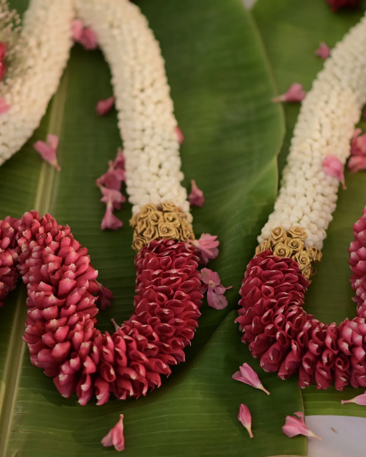 Temporary concept image of fresh flower garlands laid out on banana leaves for décor work; not property photography.