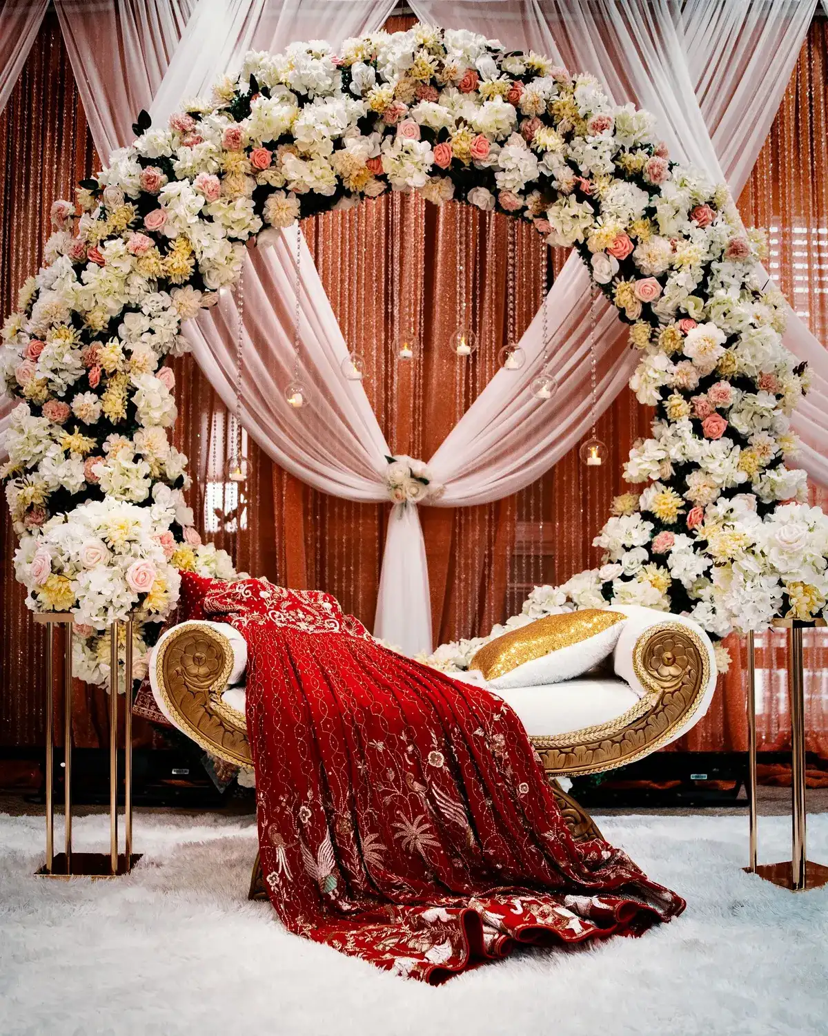 Temporary concept image of floral wedding stage with draped fabric and arched arrangements; not property photography.