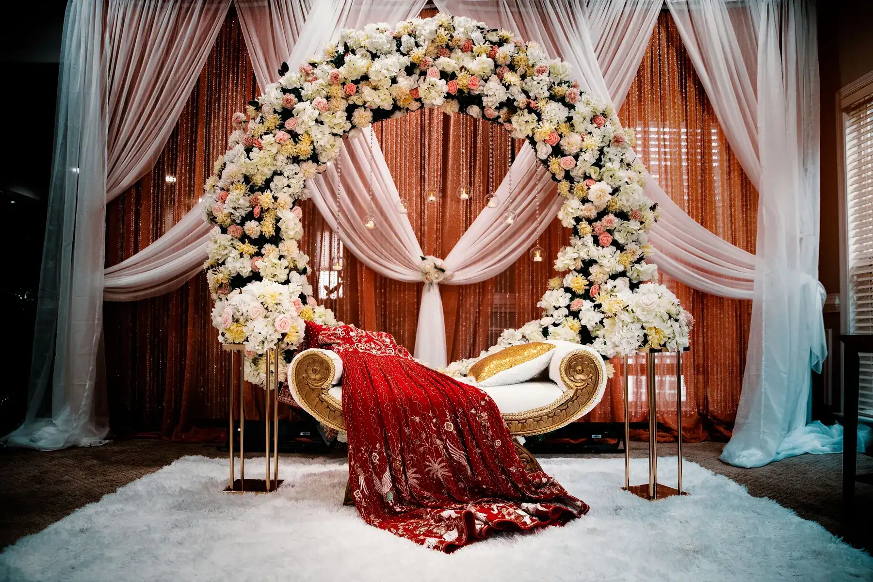 Temporary concept image of floral wedding stage with draped fabric and arched arrangements; not property photography.