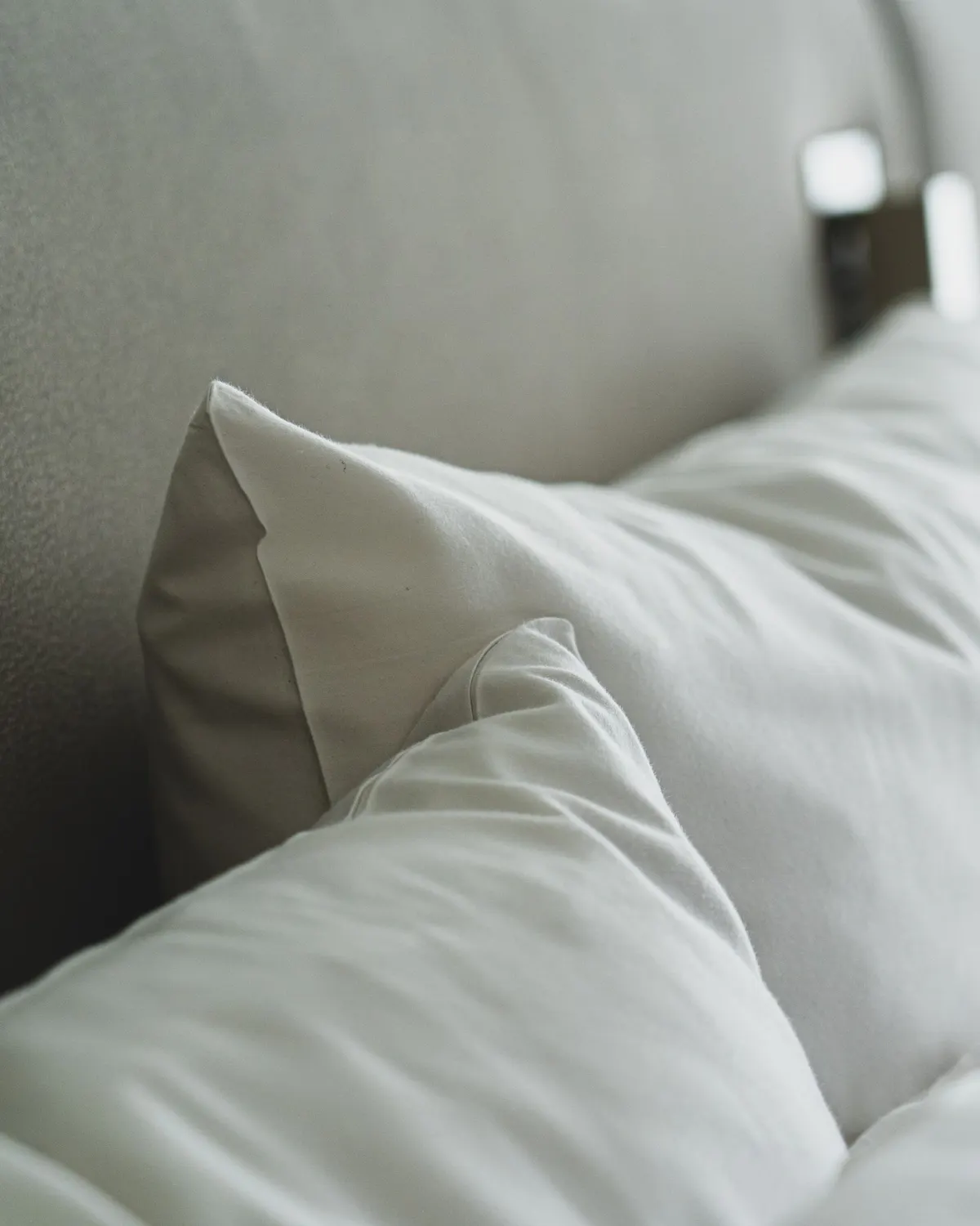 Temporary concept image of close view of freshly pressed white pillows and linen; not property photography.