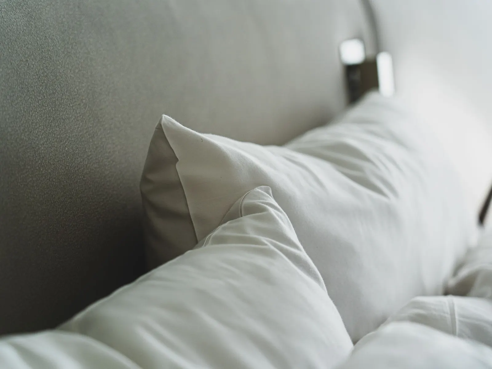 Temporary concept image of close view of freshly pressed white pillows and linen; not property photography.