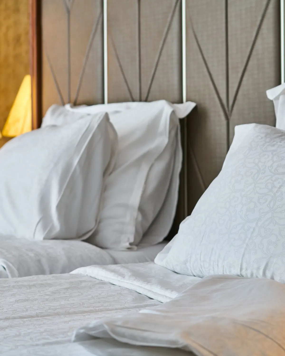 Temporary concept image of crisp white bedding and soft pillows in a calm bedroom; not property photography.