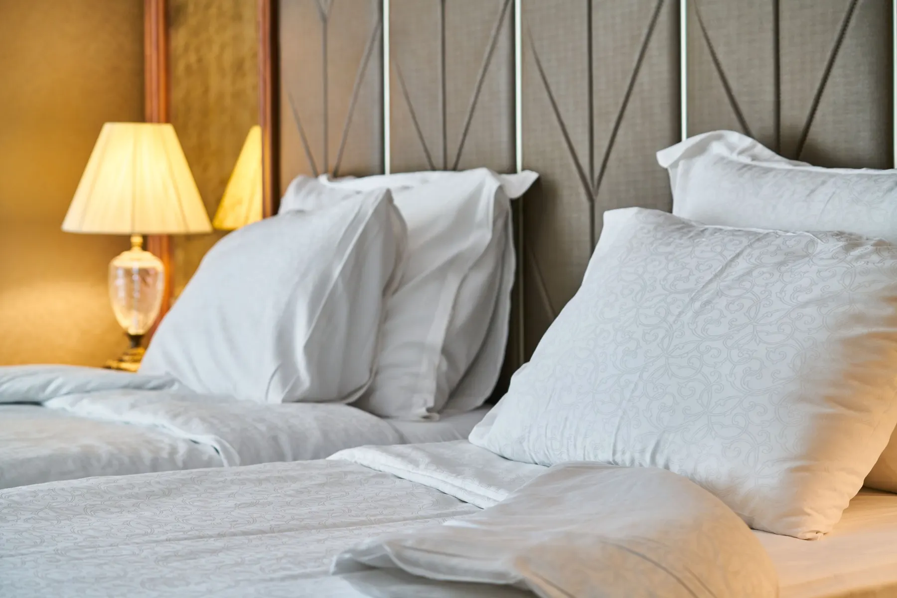 Temporary concept image of crisp white bedding and soft pillows in a calm bedroom; not property photography.