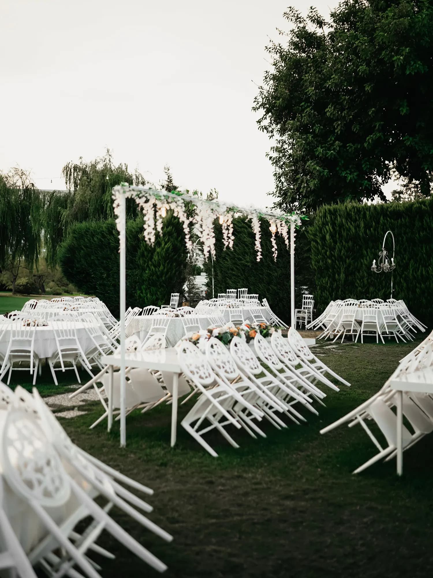Temporary concept image of rows of white chairs arranged on a green lawn for an open-air ceremony; not property photography.